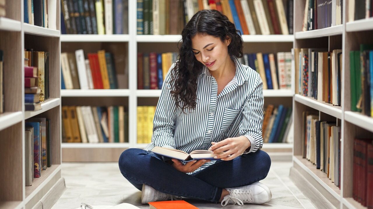 Studentin blättert durch Fachbücher