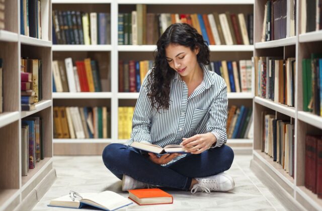 Studentin blättert durch Fachbücher
