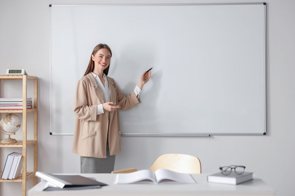 Lehrerin erklärt Schülern am Whiteboard