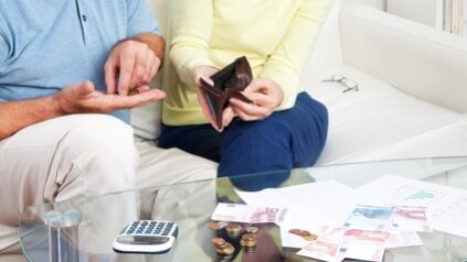 Älteres Paar zählt Geld auf dem Wohnzimmertisch