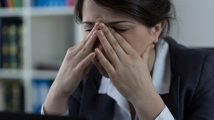 Frau mit Kopfschmerzen, Burnout Lehrerin