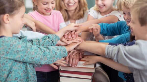 Schulkinder mit Ihrer Lehrerinvhülern im Unterricht