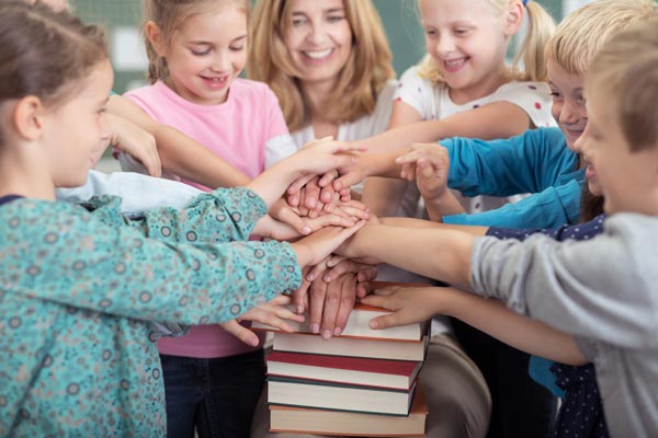 Schulkinder mit Ihrer Lehrerinvhülern im Unterricht