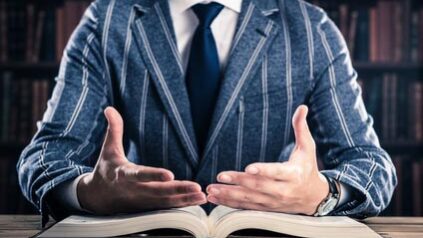 Mann sitzt vor einem geöffneten Buch
